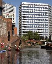 A group of people paddleboarding past the Regency Wharf