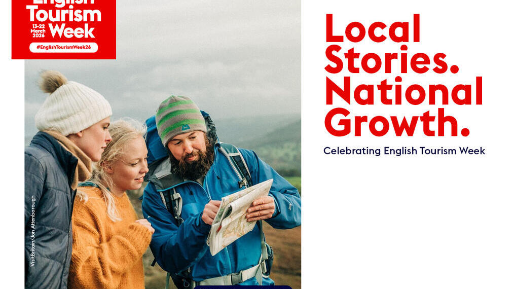 Three people in winter outdoor clothes look at a map together in the hills. Derbyshire, East Midlands. English Tourism Week banner.