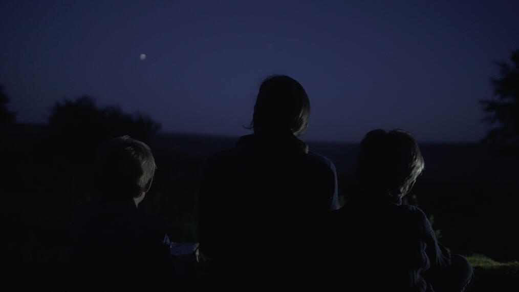 Tres personas por la noche en el festival Dark Skies en Exmoor Park