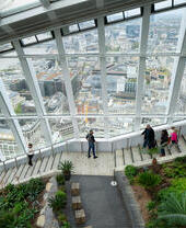 People walking down the stairs Sky Garden wth the city in the background
