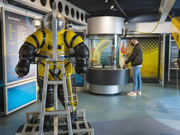 A man looking at an exhibit in a maritime museum.