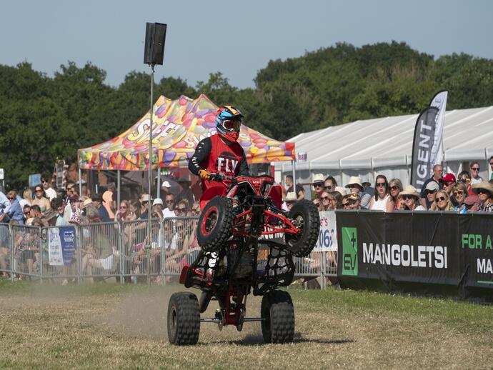 A quad bike doing a stunt in front of a crowd at the Royal Cheshire Show