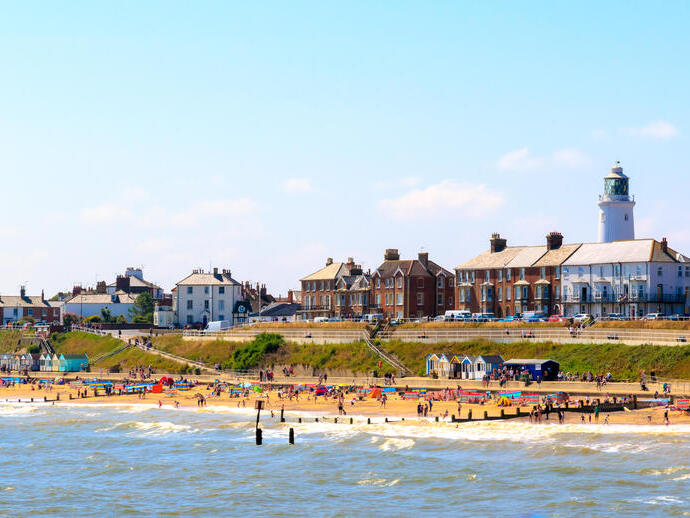 Beach with seaside cottages, beach huts and a lighthouse
