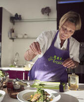 Blond woman wearing purple apron preparing food in kitchen