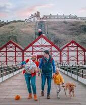 Famiglia che passeggia con un cane sotto una funicolare