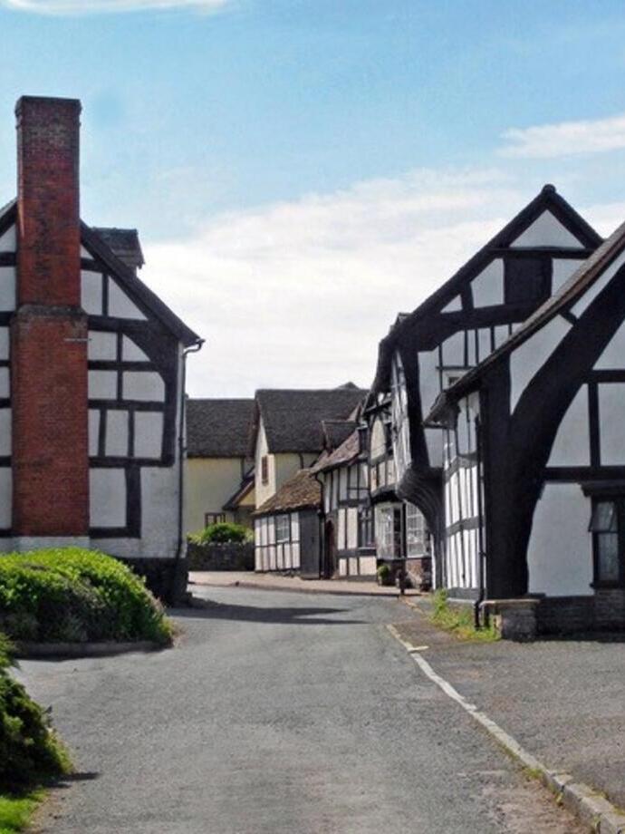 Maisons à colombages traditionnelles dans une rue étroite d’un village anglais en journée