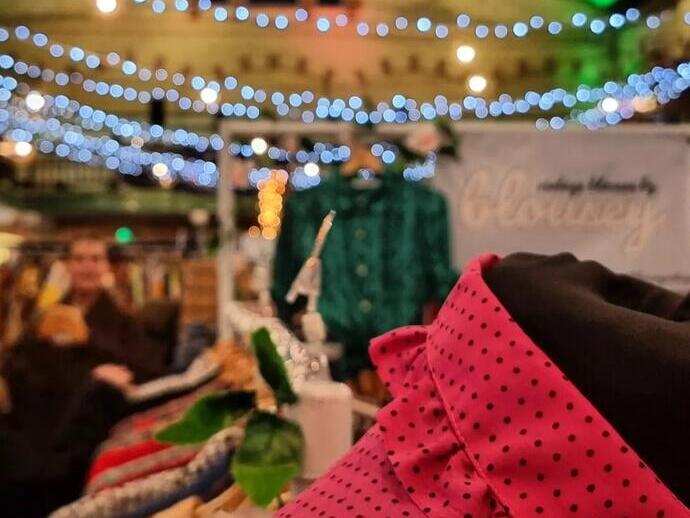 Close up of clothing on market stall at Victoria Baths with coloured lights in the background