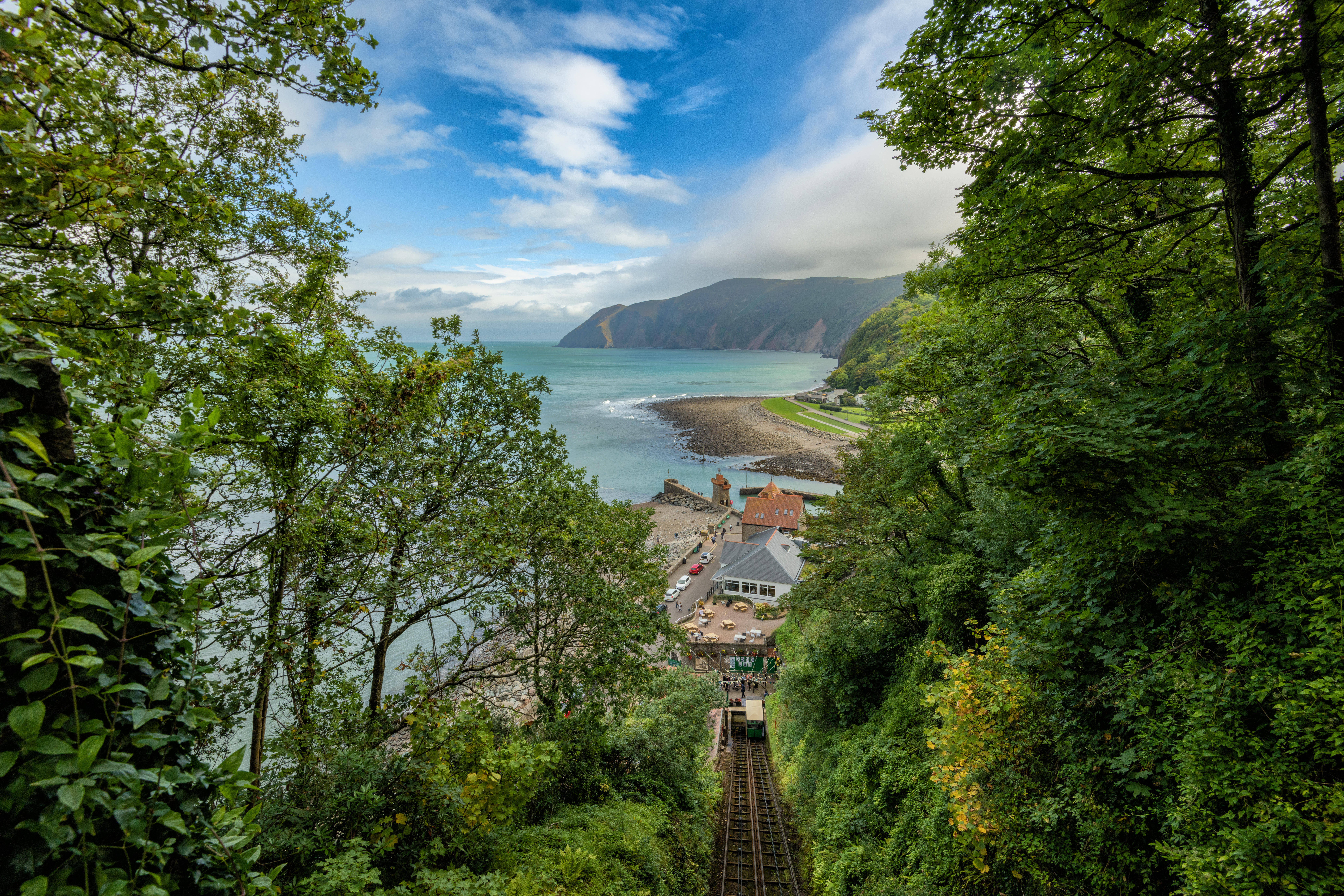 A steep railway heading down to a beach, overlooking an expansive pretty ocean.