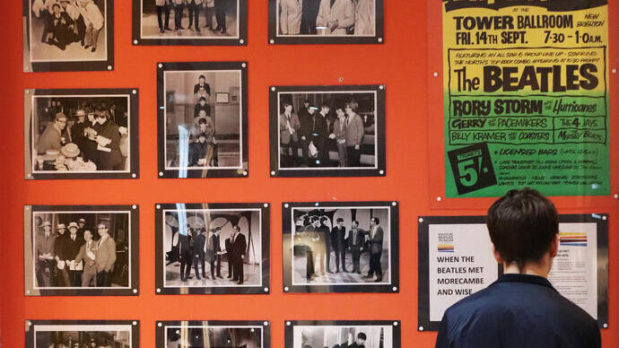 Liverpool Beatles Museum, person looking at a Beatles display on a wall.