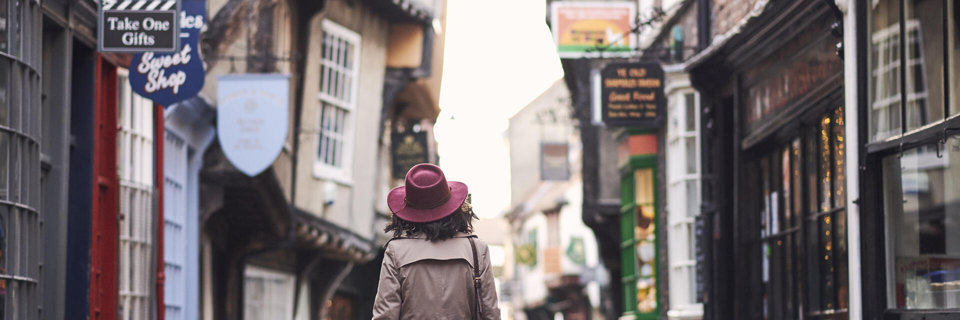 Woman walking through a narrow historic street in a city