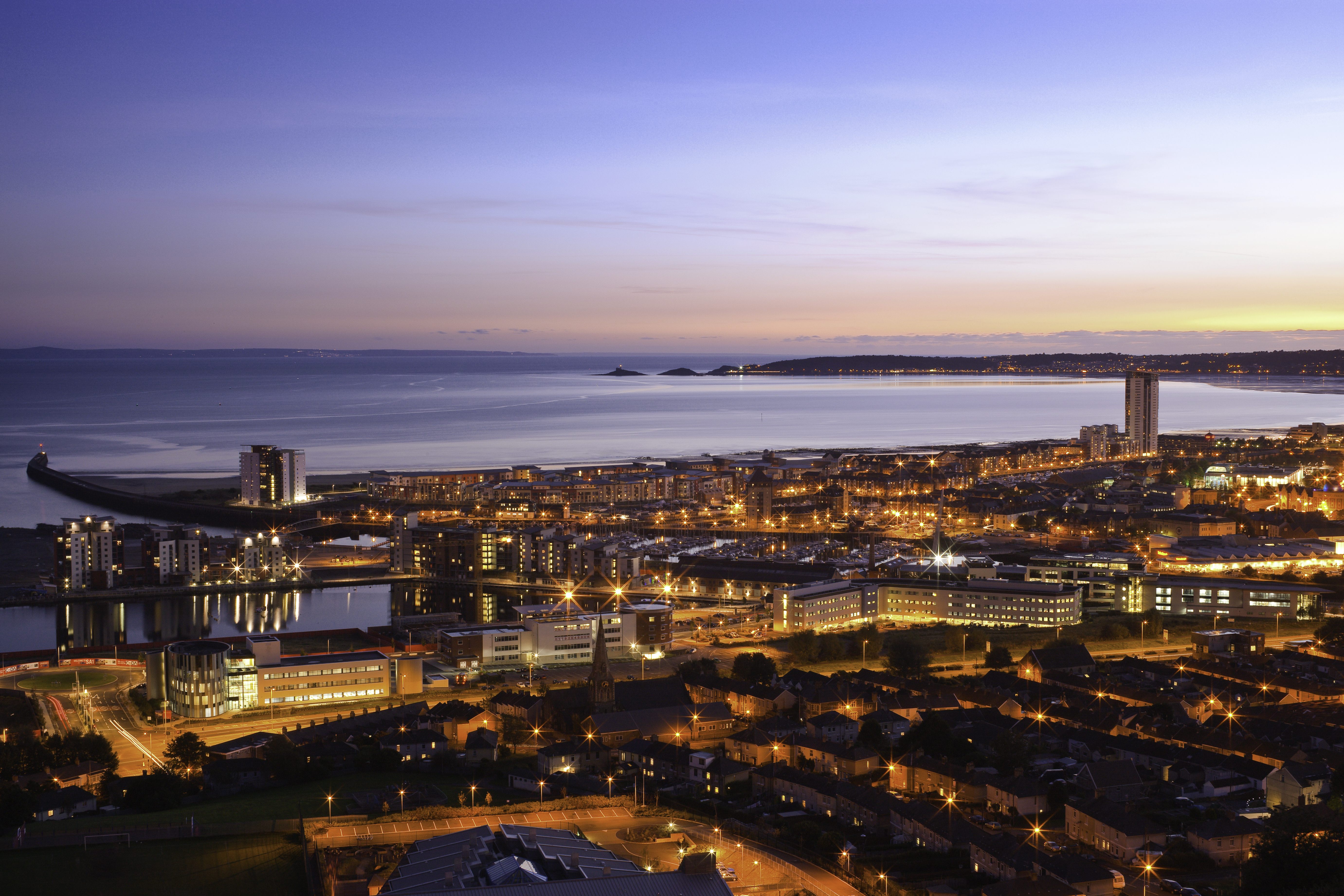 Vue aérienne de la ville et du bord de mer de Swansea au crépuscule.