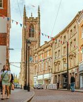 Persone che camminano lungo una strada con una cattedrale