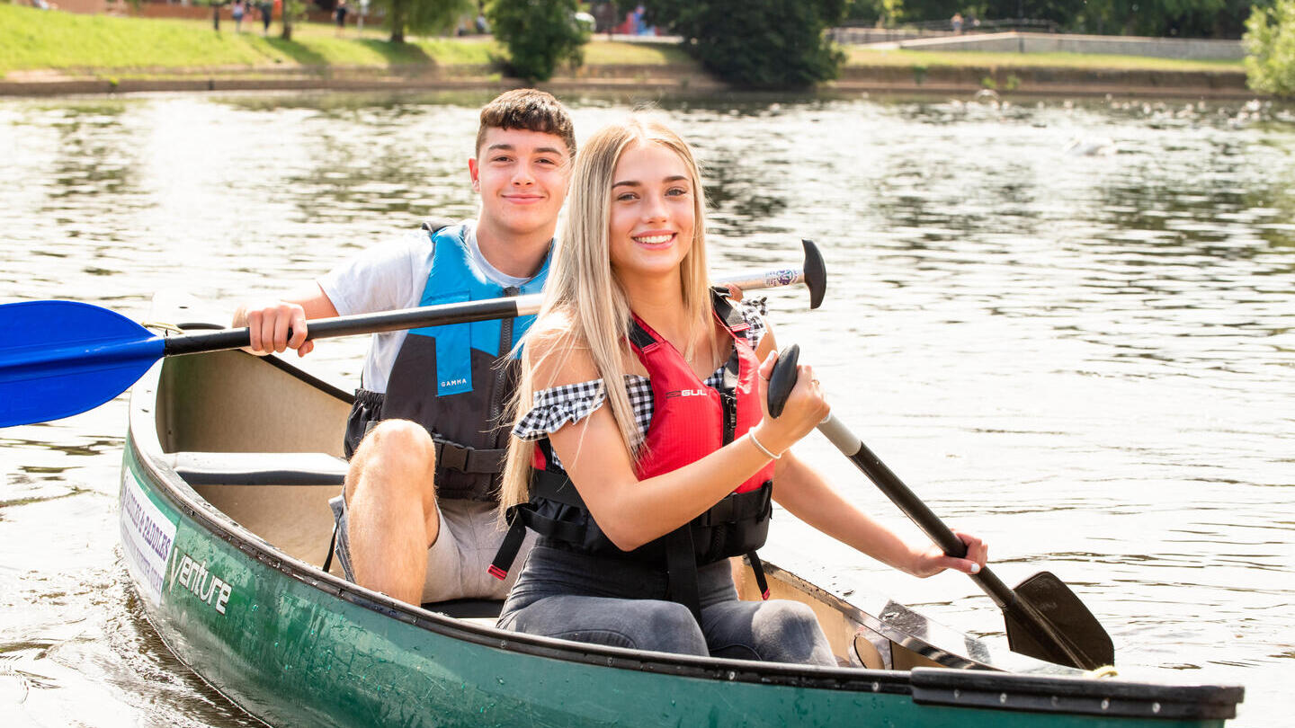 Un homme et une femme pagayant sur une rivière