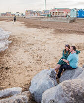 Deux personnes assises sur les rochers surplombant la mer sur la plage de Felixstowe