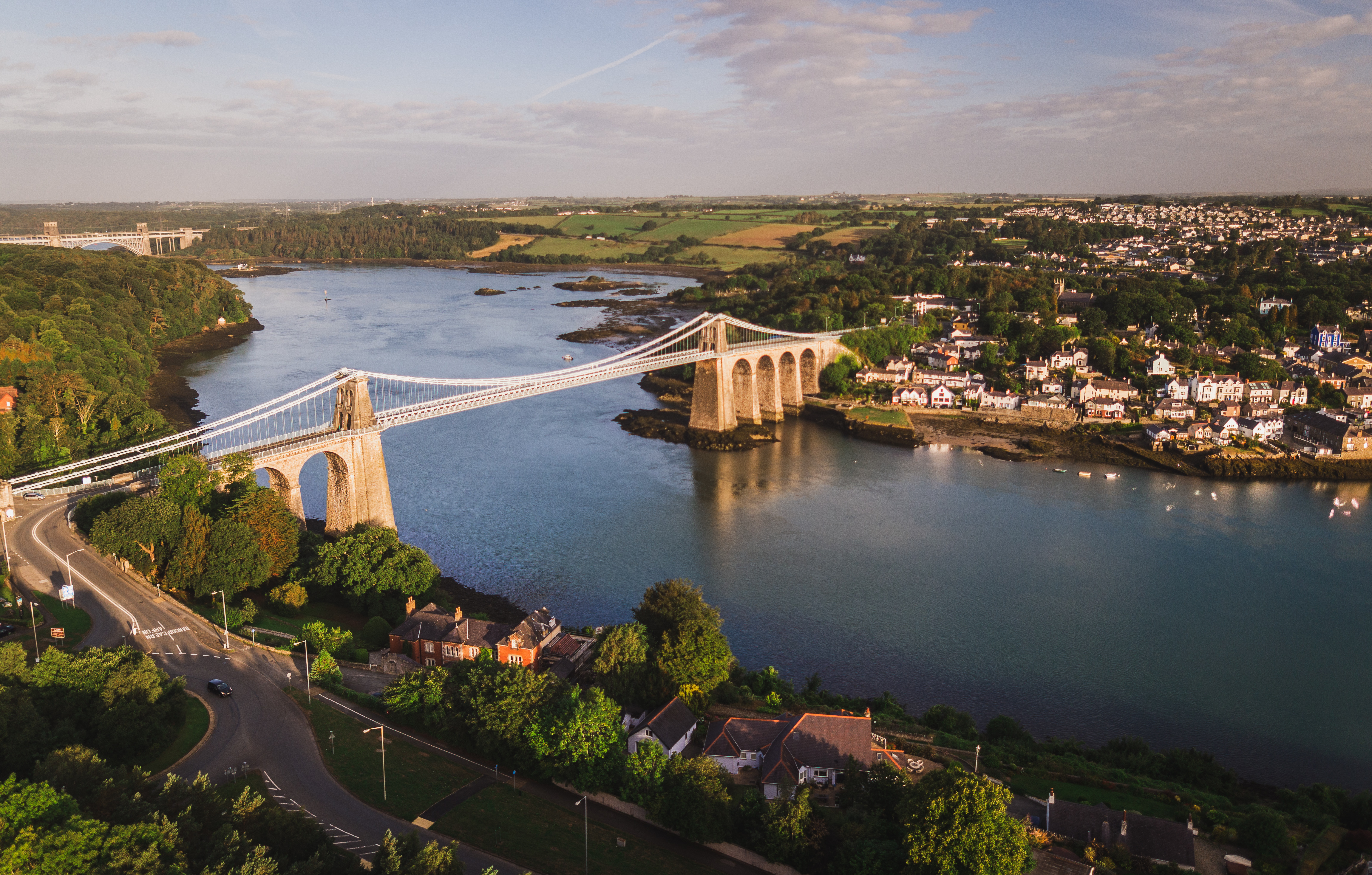 Landscape view of a suspension bridge over a river.