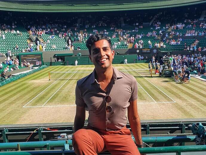 A man sitting in a seat on one of the courts at Wimbledon Tennis championships
