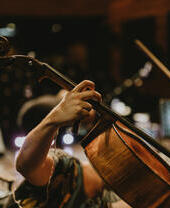 Un hombre preparando un violonchelo para un concierto.
