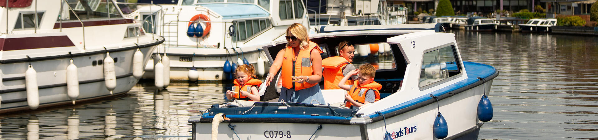 A family riding on a boat in the Norfolk Broads