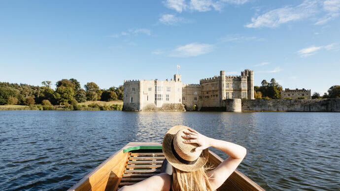 Donna su una barca a remi nel fossato che guarda verso il castello