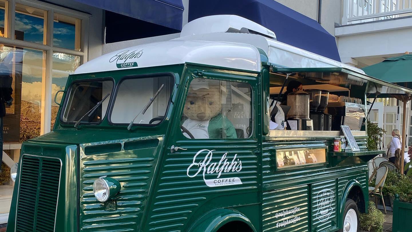 A green coloured vintage car promoting Bicester Village