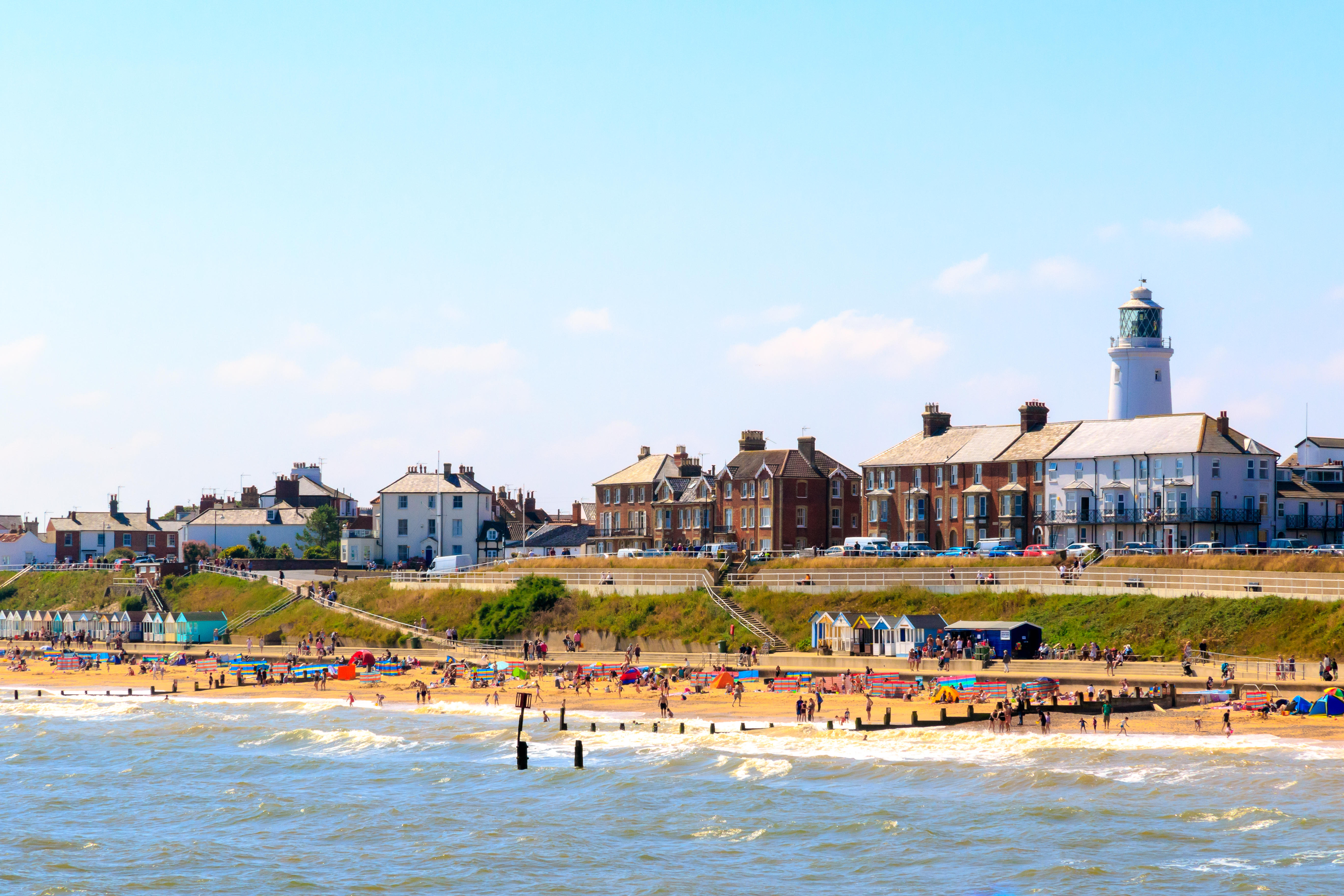 Beach with seaside cottages, beach huts and a lighthouse