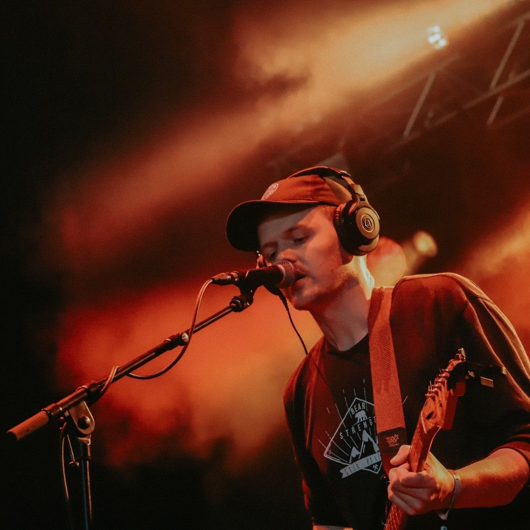 A man on stage singing and playing the guitar at the Hebridean Celtic Festival
