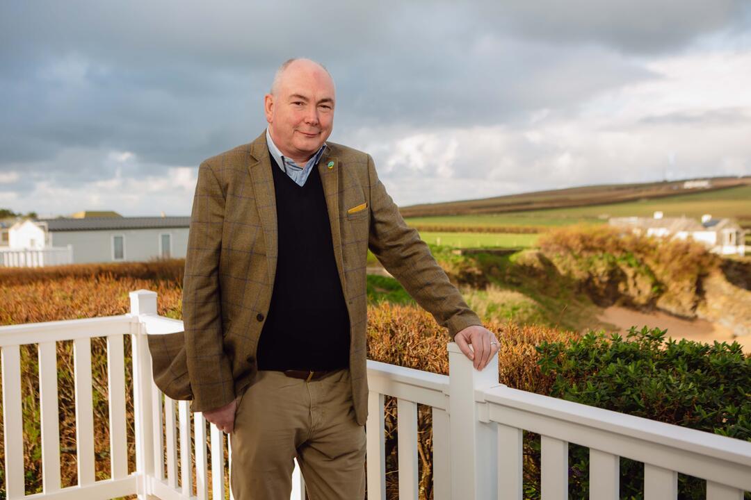 Man standing outdoor, an open field in the background
