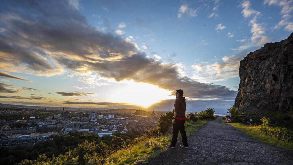 Hombre disfrutando de las vistas panorámicas de Edimburgo desde la cima de Arthur's Seat