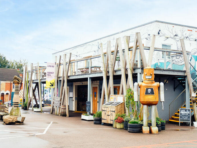Robot sculpture outside a building with geometric decor