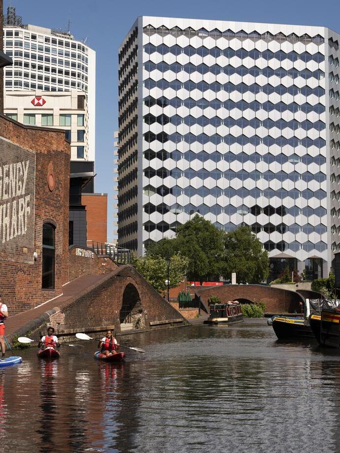 Un groupe de personnes faisant du paddleboard devant le Regency Wharf