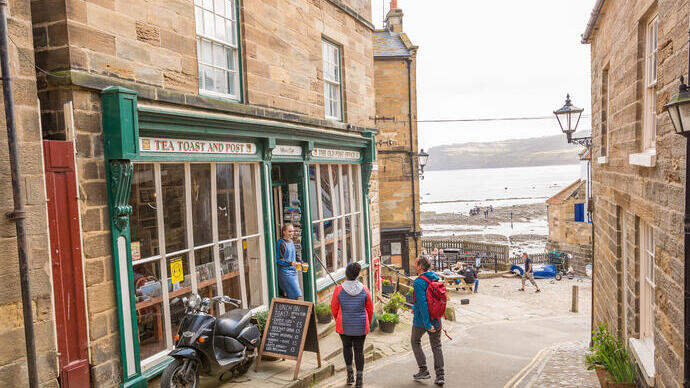 Couple marchant dans une rue étroite avec la mer au loin