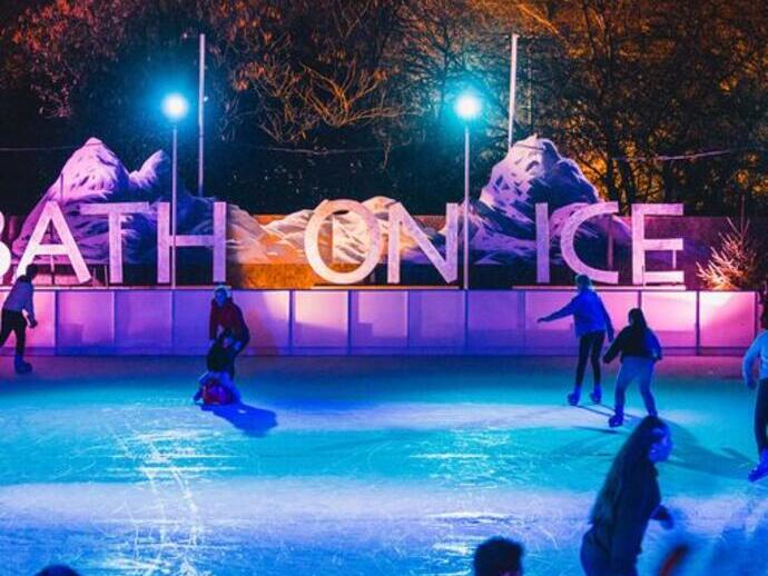 Iceskaters gliding across the ice in the evening at Bath on Ice