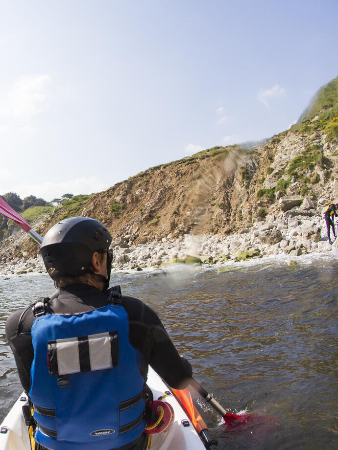 Gente haciendo kayak a lo largo de la costa