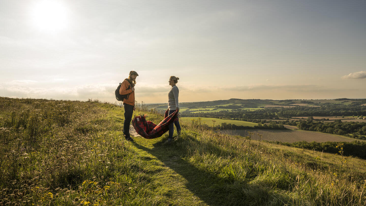 A couple walking on hilly landscape overlooking valleys