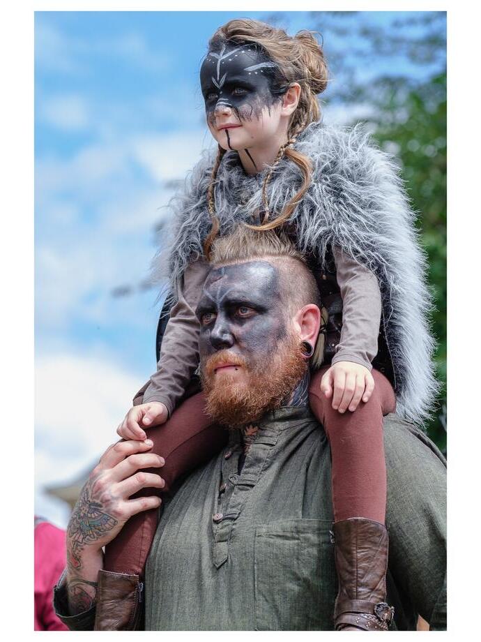 Mann mit Kind auf den Schultern, gekleidet in Wikinger-Kostüm und mit Gesichtsbemalung, Jorvik Viking Centre, York
