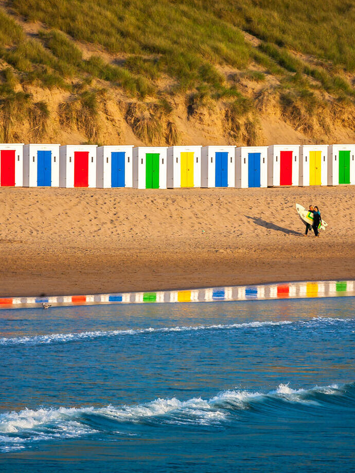 Idyllic Scene On Surfers Beach With Beautiful Beach Huts Reflecting In The Water