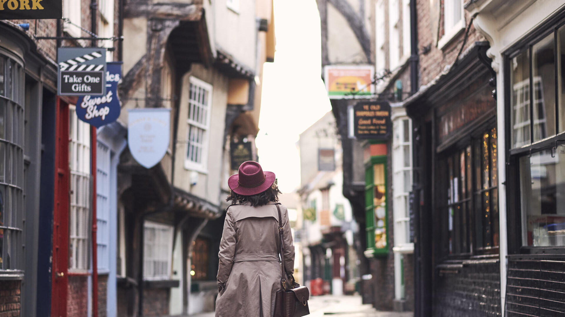Woman walking through a narrow historic street in a city