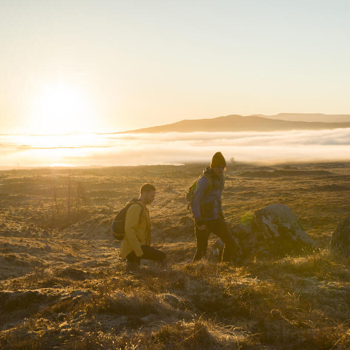 Deux hommes faisant une randonnée dans les hautes terres au coucher du soleil. Rayons de soleil