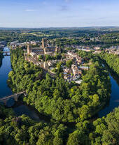 Vue en hauteur d'une cathédrale nichée entre les arbres et une rivière