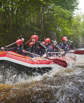 Des personnes en combinaison de plongée et casque descendant des rapides