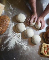 Fresh baked goods being prepared by a baker.