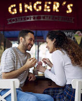 Ein Paar sitzt in einer Bar, lacht und isst Eis in einem Café