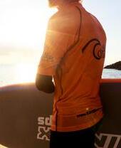 A man holding a surfboard on a beach in Cornwall