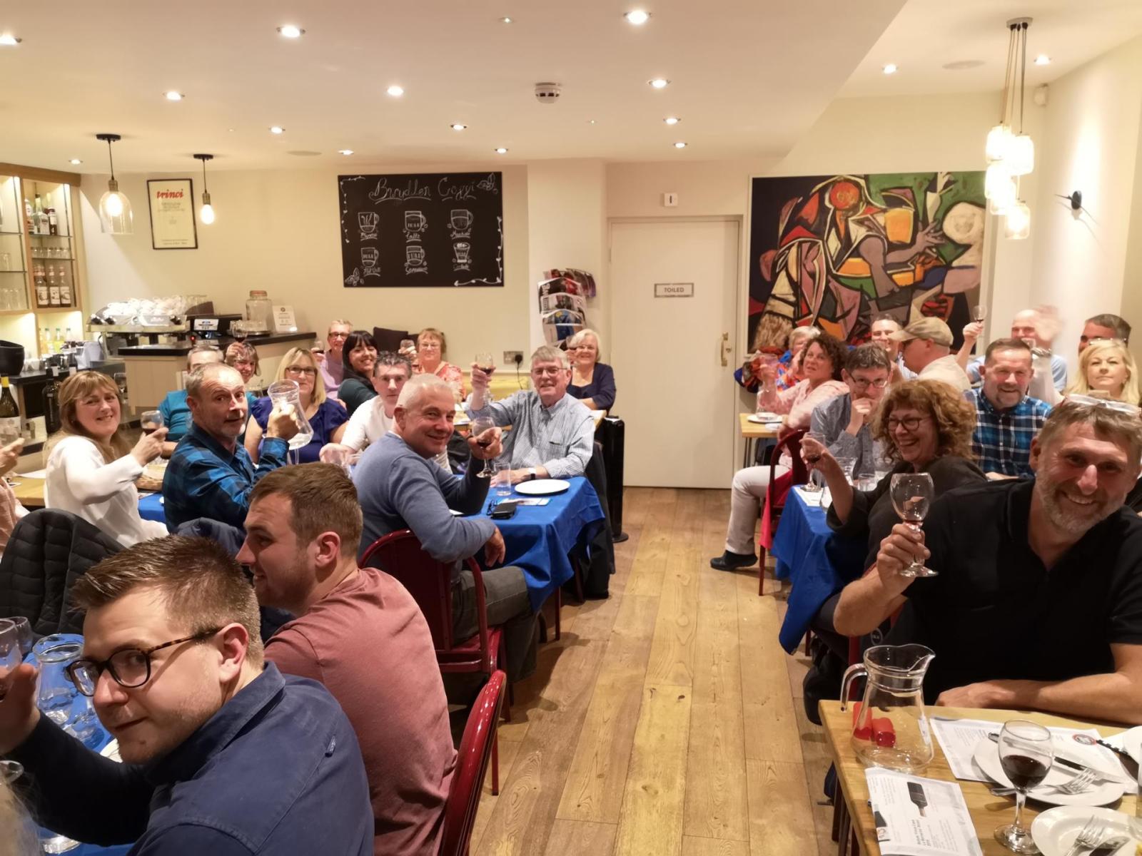 Mitglieder eines Weinclubs stoßen im Blas ar Fwyd im Snowdonia/Eryri-Nationalpark vor der Kamera an