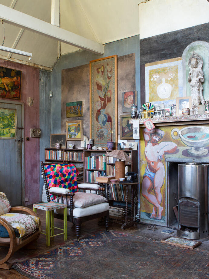 Interior of historic house with paintings on walls and decorated fireplace