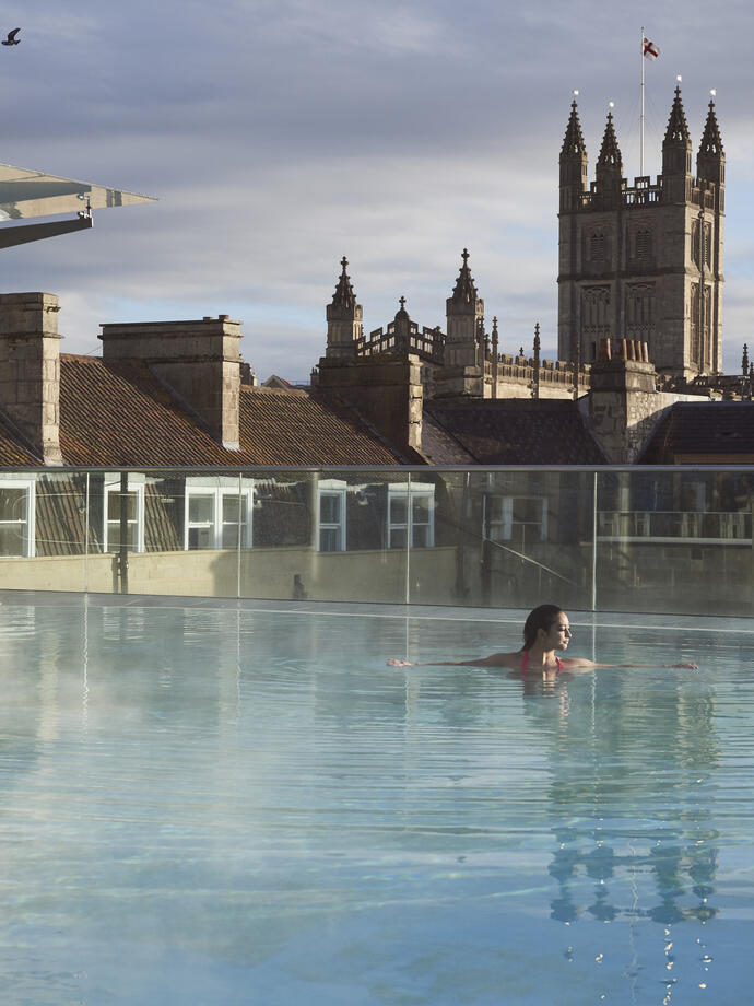 Mujer en la piscina de la azotea de un spa
