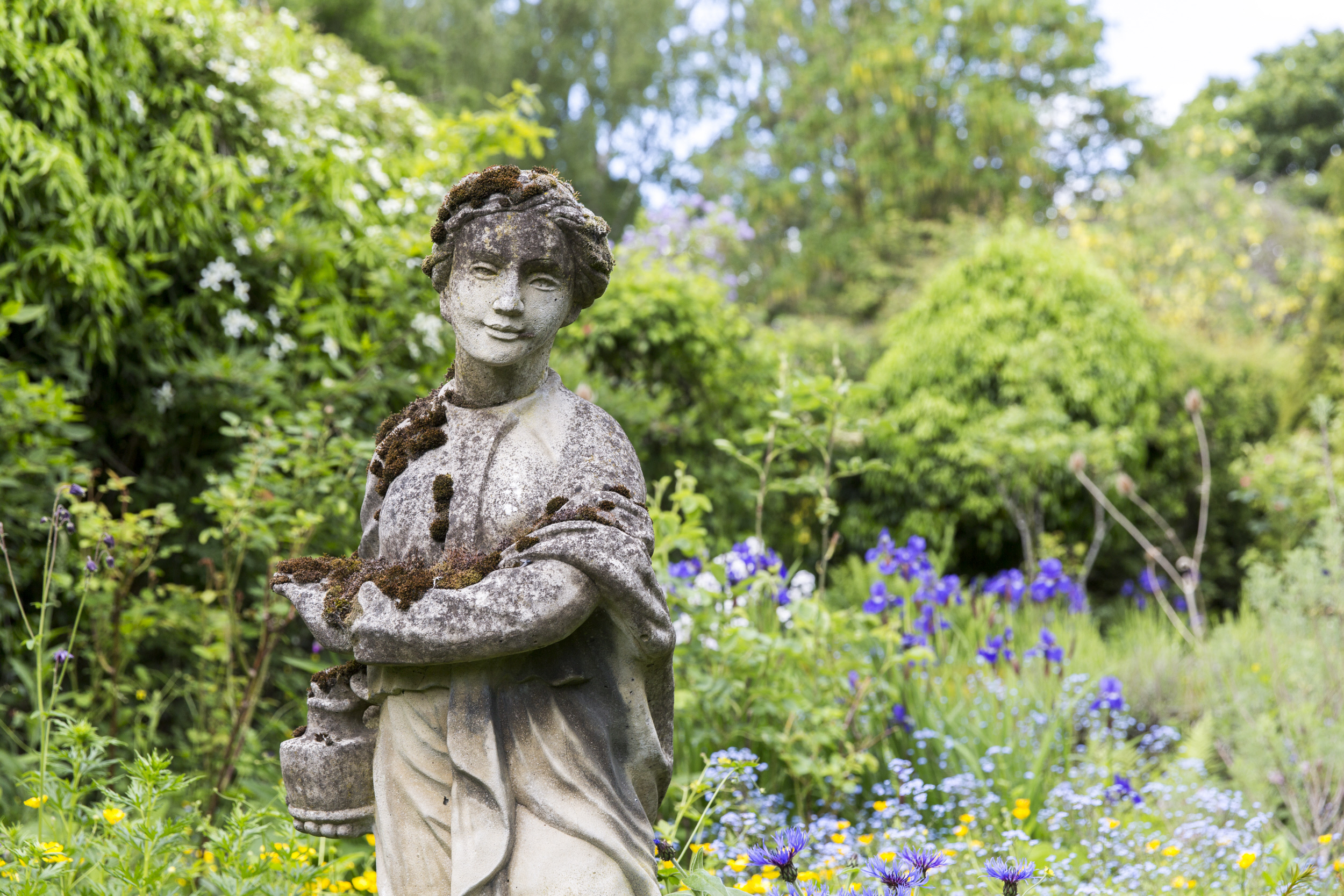 Statue recouverte de lichen et de mousse à Crook Hall Gardens, dans le comté de Durham