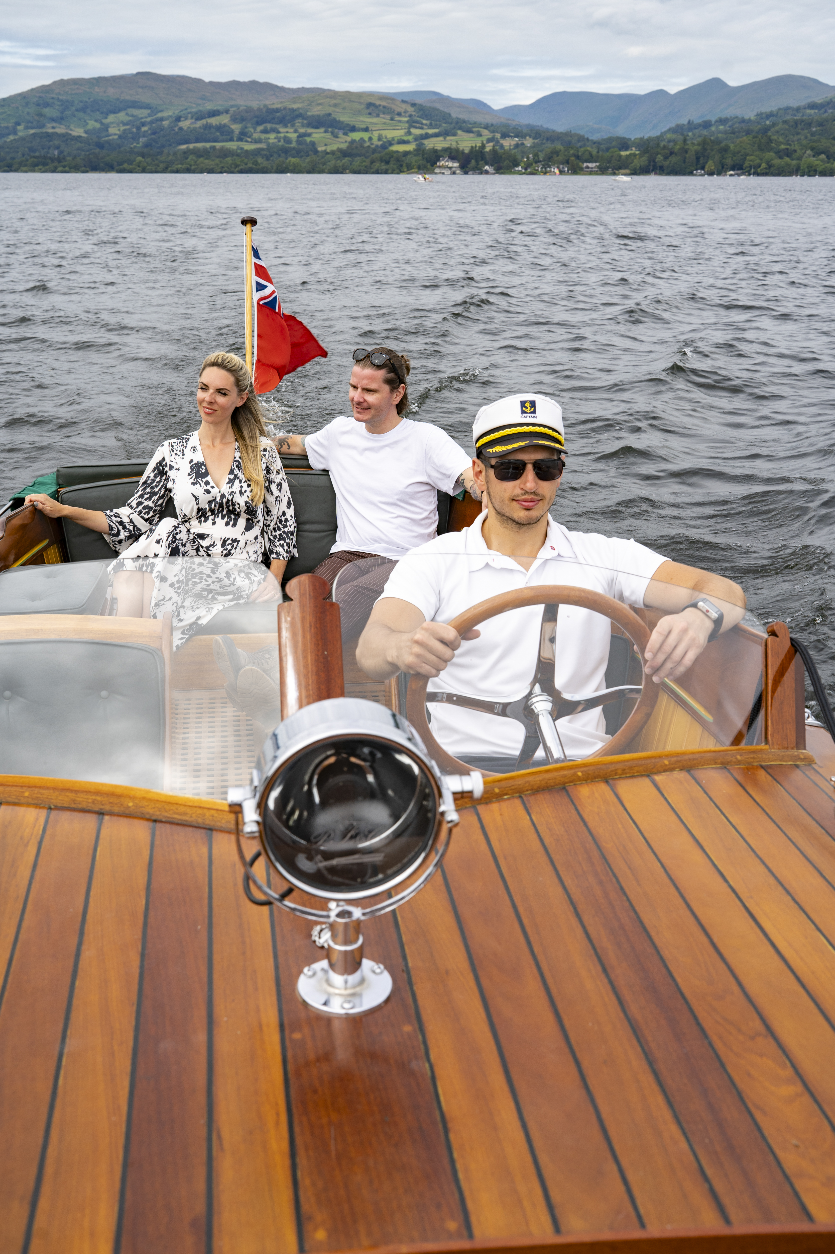 Un uomo e una donna su una barca guidata da uno skipper su un lago