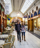 Couple arm and arm walking through an indoor market