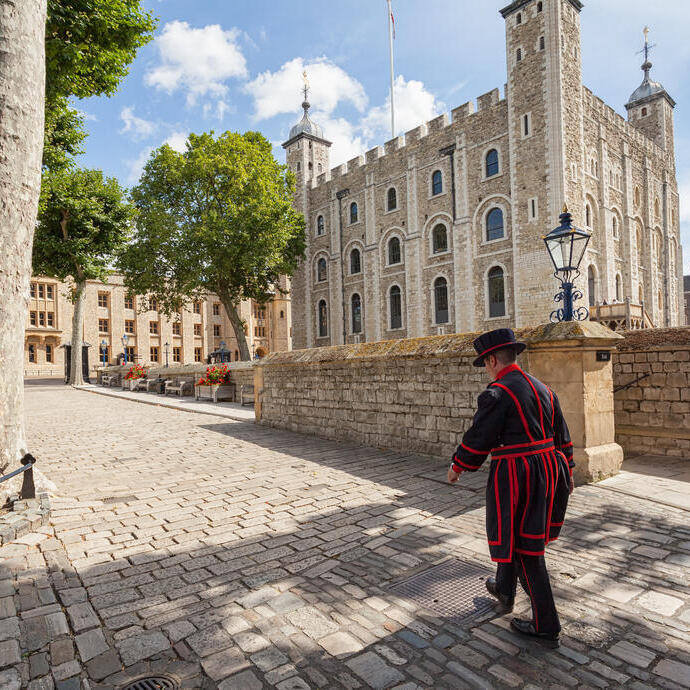 Beefeater walking by the Tower of London on a sunny day